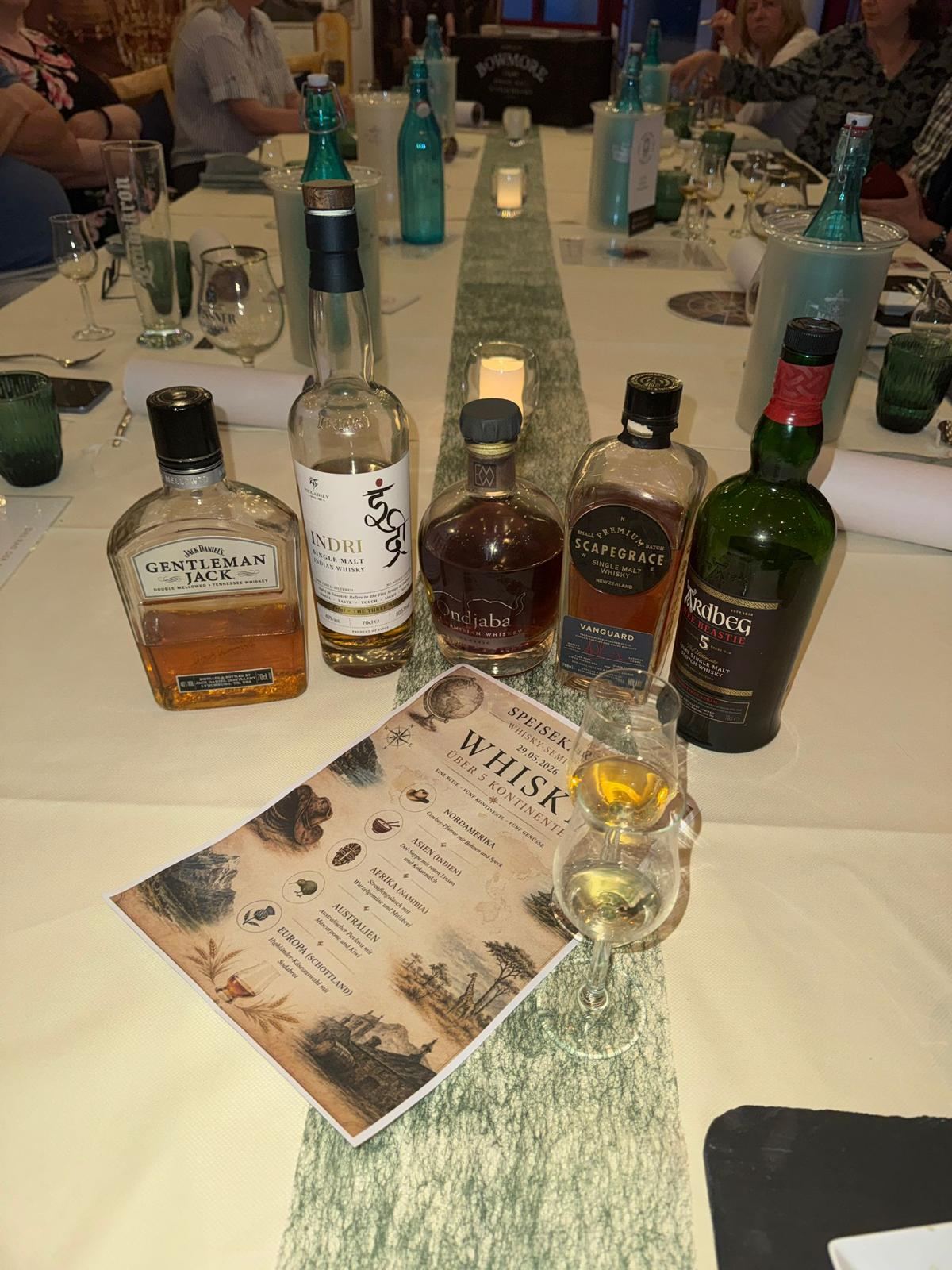 Fünf Whiskyflaschen und Seminarkarte "Whisky über 5 Kontinente"