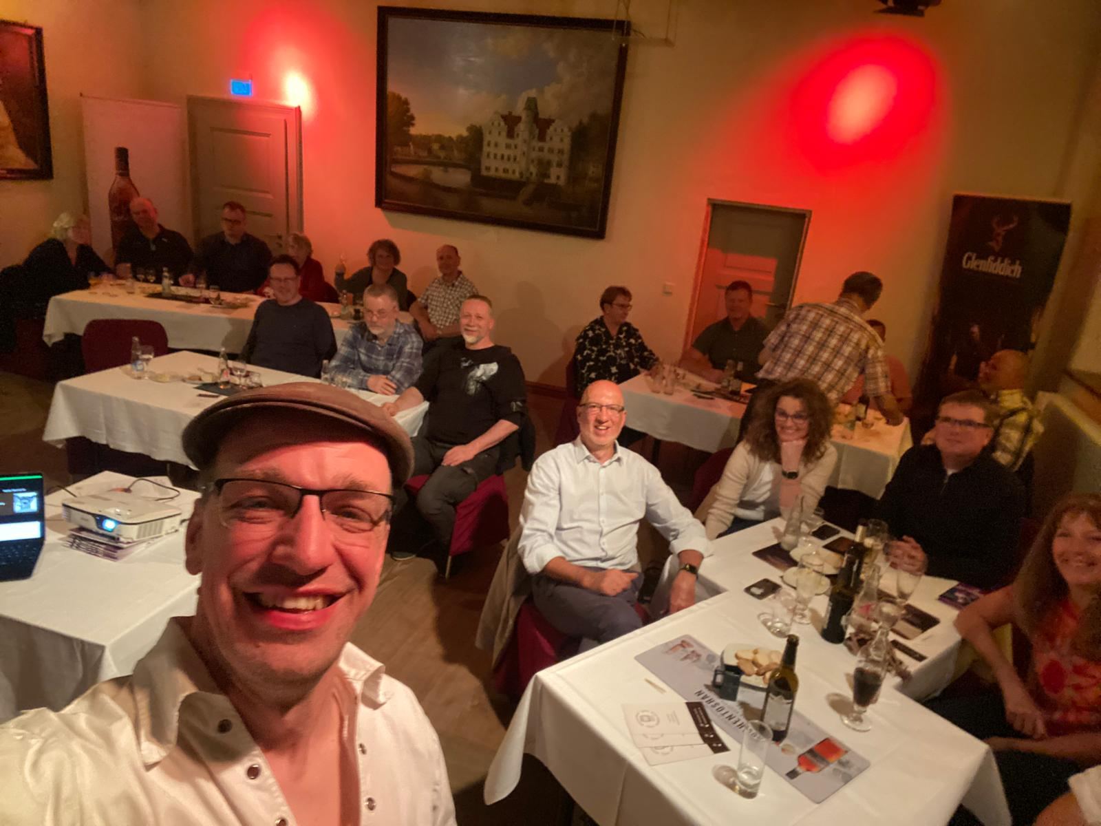 Gruppe bei einem Whisky-Seminar an gedeckten Tischen