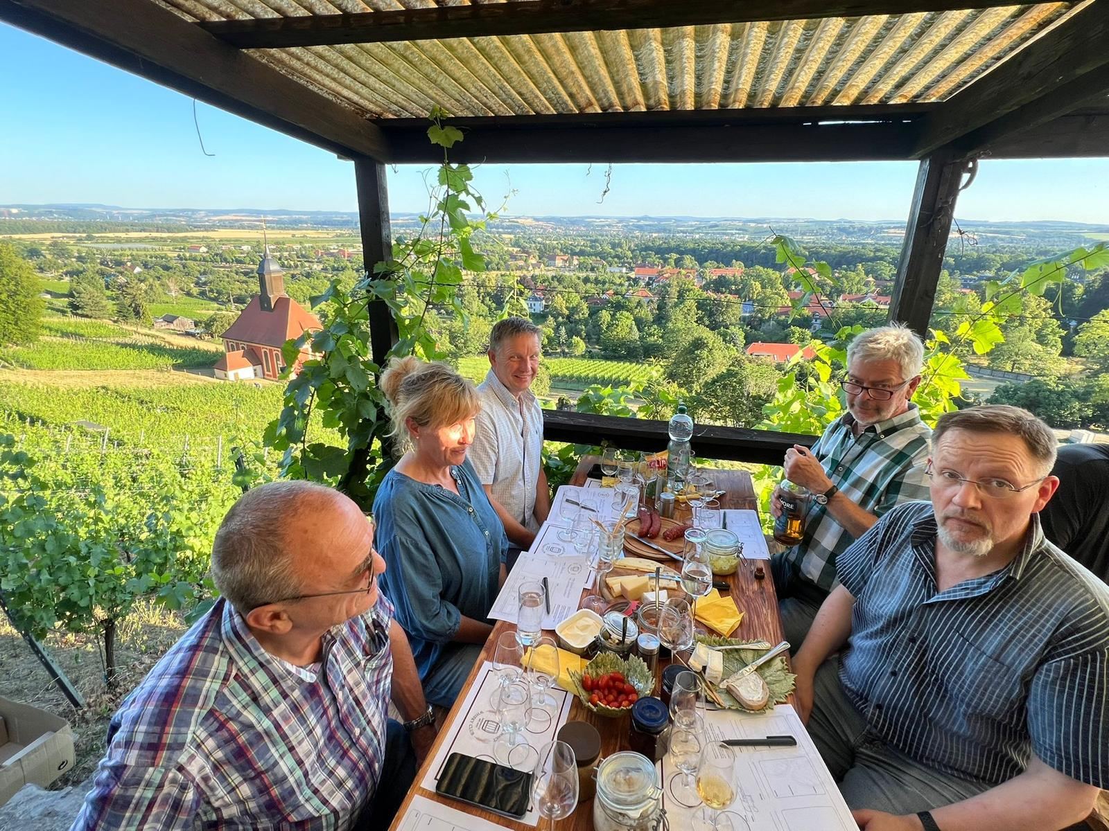 Mitglieder des Clubs an einer gedeckten Tafel im Pillnitzer Weinberg